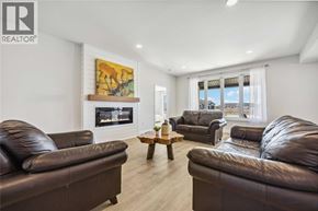 Sarnia house for rent - A living room with brown leather couches and a painting on the wall.