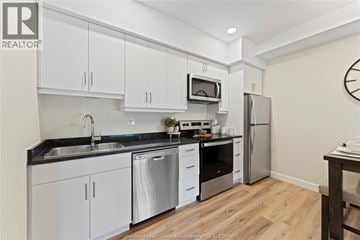 Mcgregor apartment for rent - A kitchen with white cabinets and a black countertop.