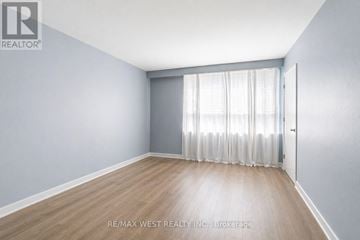 Toronto (Yorkdale-Glen Park) other for rent - A living room with a grey cabinet, a glass table and two blue chairs.