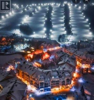 Blue Mountains house for rent - A nighttime aerial view of a snowy town with buildings lit up.
