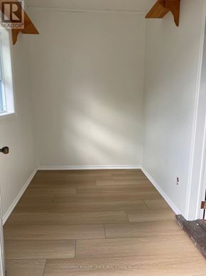 Cobourg duplex for rent - A room with wooden flooring and white walls.
