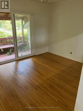 Cobourg duplex for rent - A room with wooden flooring and a door leading outside.