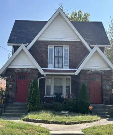 Louisville apartment for rent - A brick house with a red door and a white window.