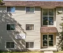Edmonton apartment for rent - A grey building with a brown roof and a sign on the front.