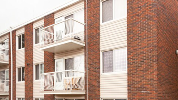 Edmonton apartment for rent - A red brick building with a balcony.