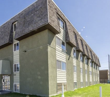 Edmonton apartment for rent - A building with a greenish facade and a grey roof.