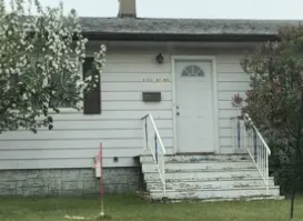 Edmonton apartment for rent - A small white house with a front porch and a mailbox.