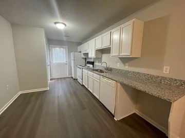 Youngsville apartment for rent - A kitchen with white cabinets and a granite countertop.