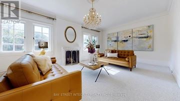 Toronto (Forest Hill South) house for rent - A living room with a tan couch and a chandelier.