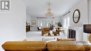 Toronto (Forest Hill South) house for rent - A living room with a chandelier, a fireplace, and a couch.