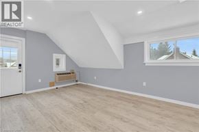Kitchener house for rent - A room with a white door and a window with a view of houses and trees outside.