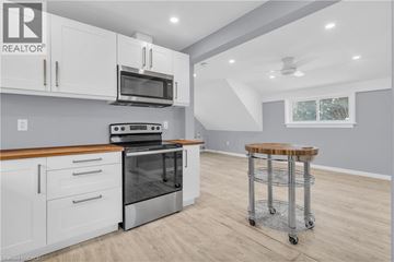 Kitchener house for rent - A modern kitchen with white cabinets and a wooden countertop.