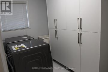 Mississauga (East Credit) house for rent - A black stove is in a kitchen with white cabinets.