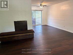 Toronto (West Hill) house for rent - A room with a wooden floor and a brown couch.