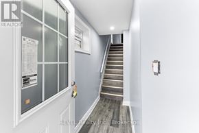 St. Catharines (E. Chester) duplex for rent - A staircase with a glass door and a sign on it.