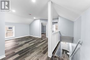 St. Catharines (E. Chester) duplex for rent - A room with wooden flooring and white walls, with a staircase on the right side.