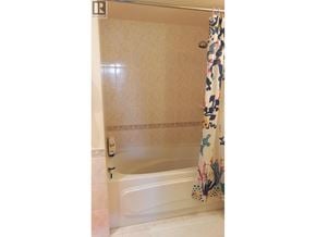 Vancouver apartment for rent - A white bathtub with a floral shower curtain.
