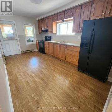 Cornwall multi-family for rent - A kitchen with wooden floors and black appliances.