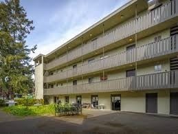 Esquimalt apartment for rent - A large apartment building with a parking lot in front.