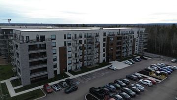 Moncton apartment for rent - A parking lot in front of a multi-story apartment building.