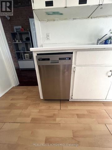 Toronto (Greenwood-Coxwell) other for rent - A dishwasher is in a kitchen with a white countertop and wooden flooring.
