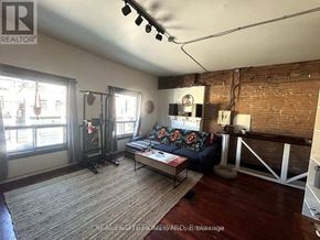 For rent in Toronto (Greenwood-Coxwell) - A living room with a couch, a coffee table, and a fireplace.