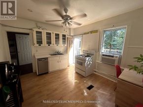 For rent in Toronto (Greenwood-Coxwell) - A kitchen with a fan and wooden floors.