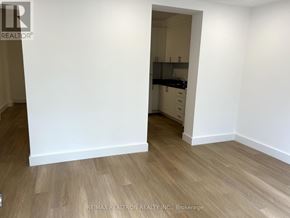 For rent in Toronto (Greenwood-Coxwell) - A room with a white wall and wooden flooring.