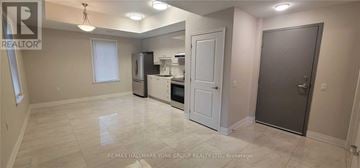 Aurora (Aurora Village) multi-family for rent - A spacious kitchen with white appliances and a white door.