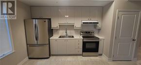 Aurora (Aurora Village) multi-family for rent - A kitchen with a refrigerator, sink, and stove.