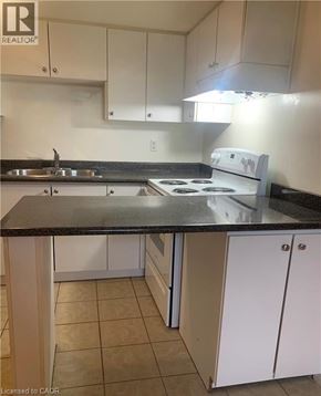 Dundas apartment for rent - A kitchen with white cabinets and a black countertop.