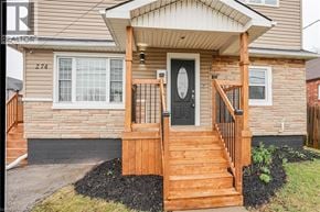 Stoney Creek house for rent - A house with a black door and a wooden staircase leading to the entrance.