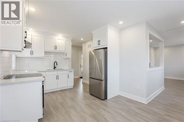 Stoney Creek house for rent - A modern kitchen with white cabinets and a refrigerator.