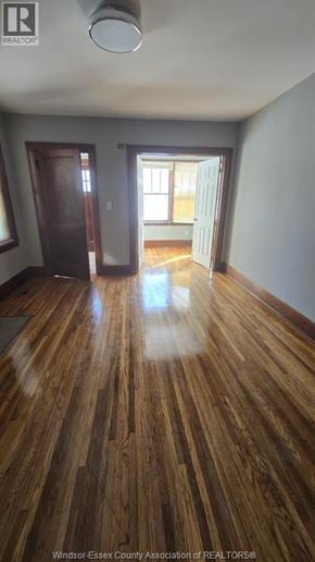 Windsor house for rent - A room with wooden floors and a door leading to another room.