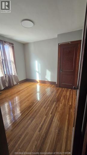 Windsor house for rent - A room with wooden flooring and a closed door.