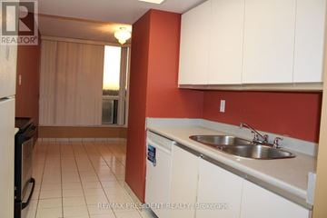 Toronto (Mount Olive-Silverstone-Jamestown) condo for rent - A kitchen with white cabinets and a red wall.