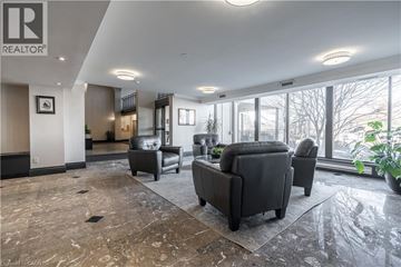 Stoney Creek condo for rent - A living room with a grey sofa and a large window.