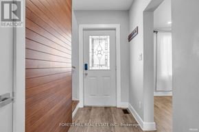 Hamilton (Gibson) house for rent - A white door with a stained glass window is in a hallway with wood flooring.
