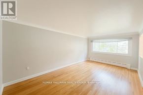 Ottawa multi-family for rent - Empty room with a window and wooden floor.