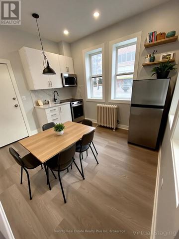 Toronto (Church-Yonge Corridor) multi-family for rent - A kitchen with a table and chairs in front of a window.