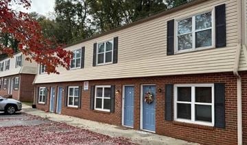 Clemson apartment for rent - A building with a blue door and windows with black shutters.