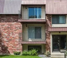 Edmonton apartment for rent - A red brick house with a balcony on the second floor.