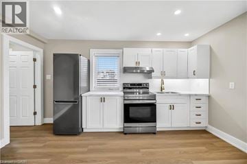 Hamilton apartment for rent - A kitchen with white cabinets and a black refrigerator.