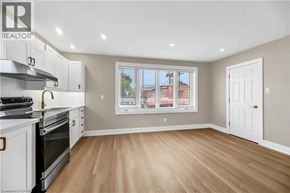 Hamilton apartment for rent - A kitchen with white cabinets and a window with blinds.