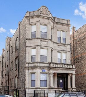 Chicago apartment for rent - a tall building with a car parked in front of it