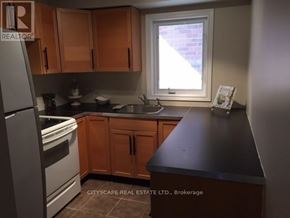 Mississauga (Churchill Meadows) house for rent - A kitchen with wooden cabinets and a black countertop.