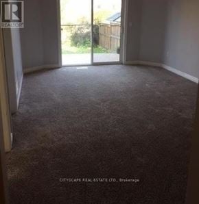 Mississauga (Churchill Meadows) house for rent - A carpeted room with a sliding glass door leading outside.
