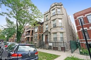 Chicago apartment for rent - an apartment building with cars parked in front of it