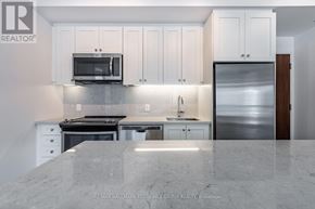 Innisfil condo for rent - A kitchen with white cabinets and a marble countertop.