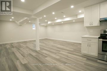 Vaughan (Patterson) house for rent - A spacious kitchen with white cabinets and a wooden floor.